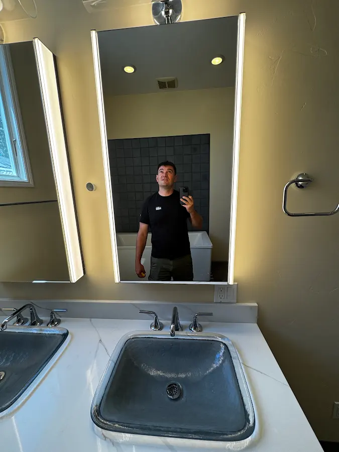 Ivan in the bathroom mirror with the finished tub visible behind him