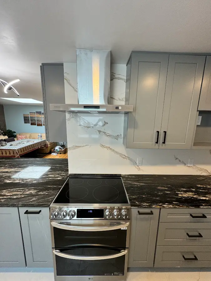 Range hood and marble-pattern backsplash above the stove